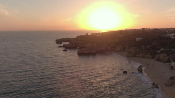 Aerial view of sunset over the coast and beach alt