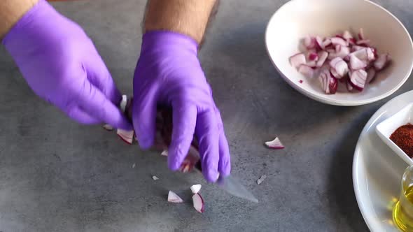 Chef chopped red onions in oil in a hot frying pan