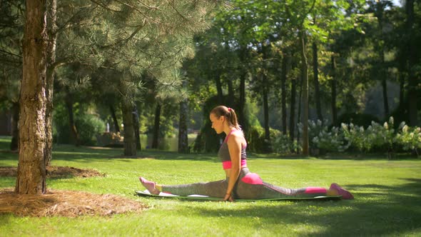 Attractive Sporty Woman Doing Splits Outdoors alt