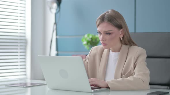 Businesswoman Thinking While Working on Laptop in Office alt