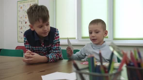 African American Teacher and a Group of Children are Learning Numbers While Sitting at the Table in alt