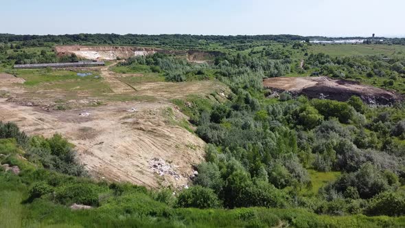Aerial drone view of a flying over the technogenic landscape among rural agricultural fields. alt