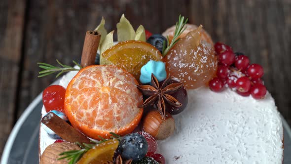 Festive New Years Cake Decorated with All Sorts of Fruits Spinning on a Rotating Stand alt