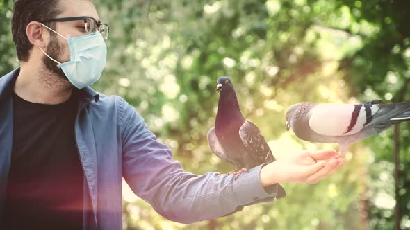 a Man in a Medical Mask Holds a Dove on His Hand