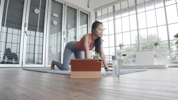 Beautiful Asian female in sportswear doing stretching yoga exercise workout.