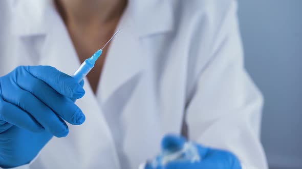 Female Nurse Preparing Injection Syringe, Filling With Ampoule Liquid, First Aid alt