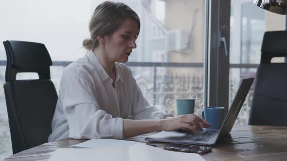 Young Woman Works for a Laptop in the Office Make the Business Correspondence alt