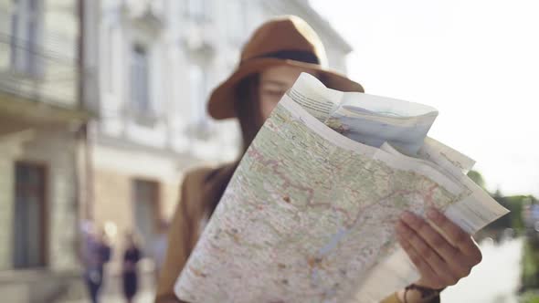 Hipster Girl with Backpack Using and Looking at Map alt