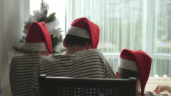 brothers children in Christmas hats write a letter