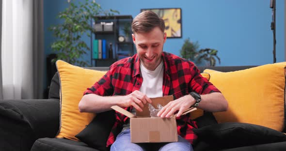 A Teenage College Boy Unpacks a Package alt