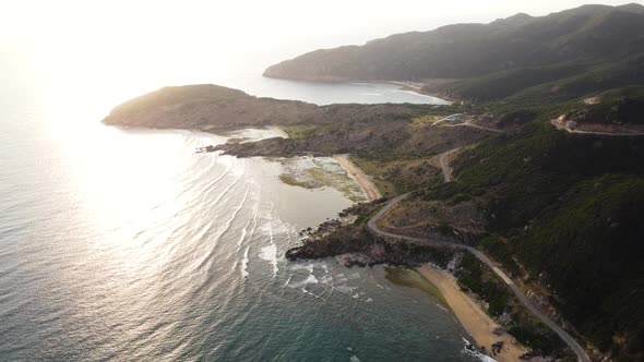 Seascape with beach and sunbeams reflecting in sea. Aerial backwards. Vietnam alt