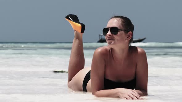 Young Woman in Black Bikini Tans on a Paradise White Sandy Beach Lies By Ocean alt