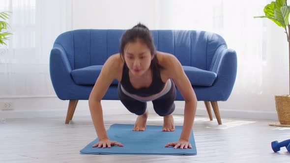 Asian girl doing push ups workout exercise on exercise mats concentration on shoulder muscle alt