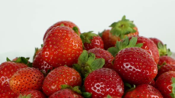 Juicy ripe exotic strawberry rotates on a white background 360. Eco fruits and berries summer.