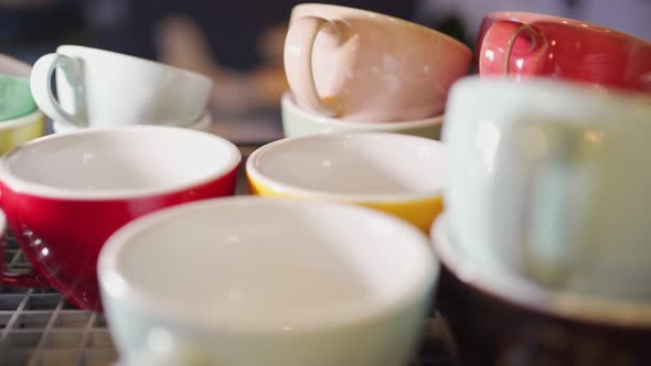 View of Colored Ceramic Mugs for Coffee Which Stand in a Special Place for Warming Up on a Coffee alt