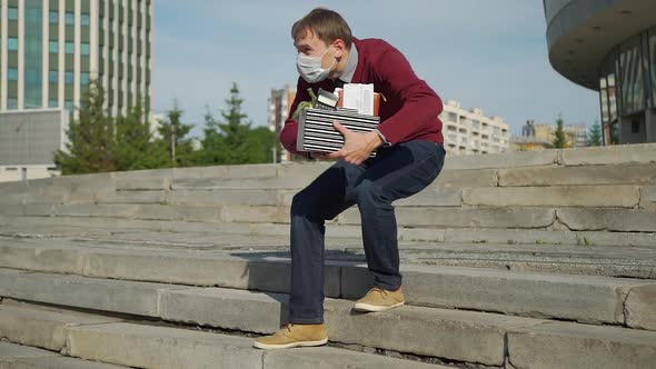 Fired Employee Taking Off Medical Mask Outdoors alt