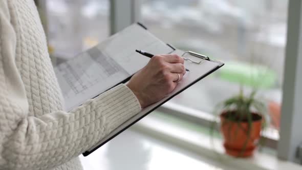 Construction engineer in the office makes calculations for the reinforcement of the building. alt