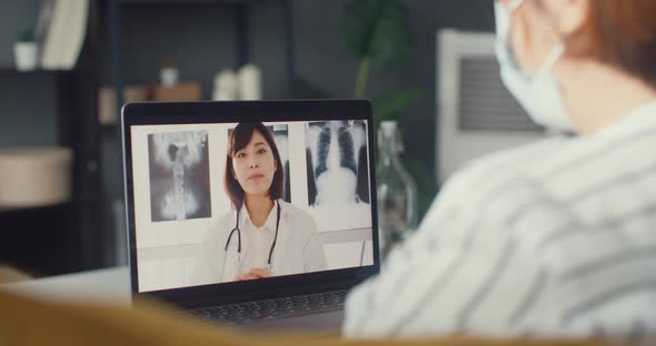 Asia girl wear protective face mask using laptop talk about disease in video call with senior doctor alt