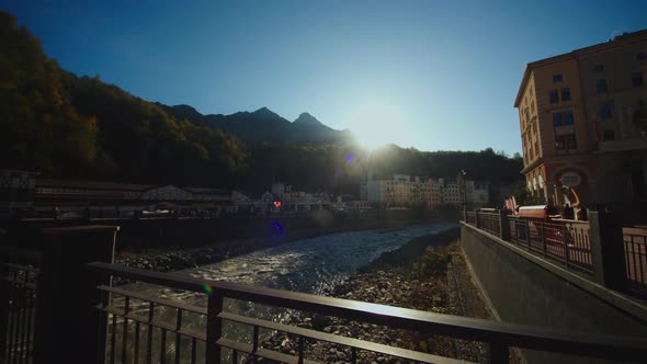 Embankment with Hotels and Restaurants of Olympic Village Rosa Khutor with Flowing Water Stream