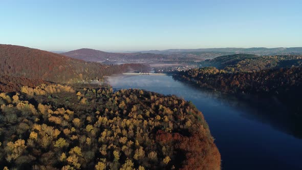 Aerial view of dam, river and mountains at fall. Aerial view of beautiful colorful fall landscape.