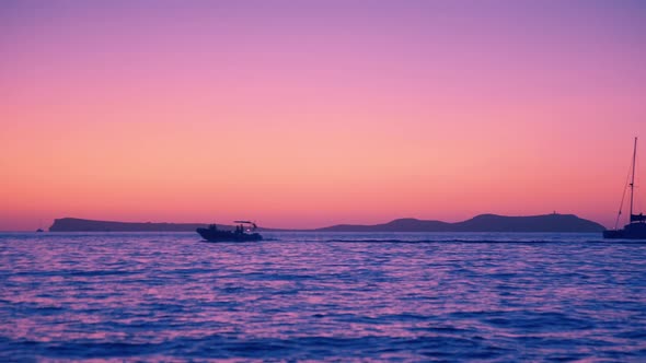 Post Sunset Purple Afterglow in the Sea wtih Mountains in the Background 4K