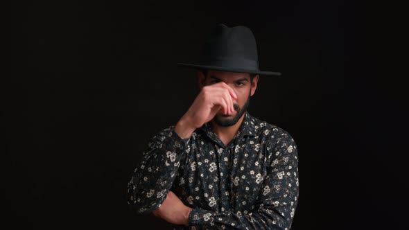 Seductive Handsome Masculine Cuban Guy in a Floral Shirt Touching His Black Hat and Looking at alt