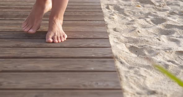 Feet on Wooden Boardwalk on Beach alt