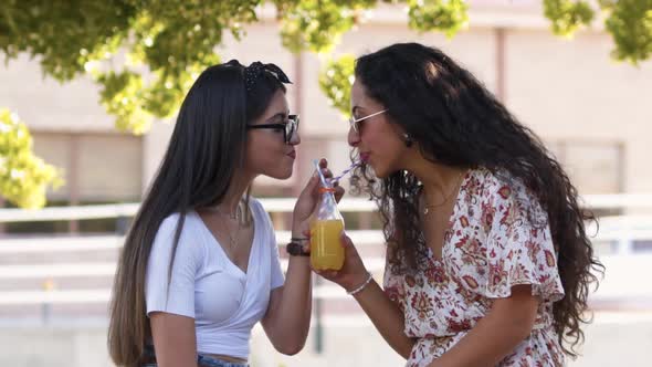Hipster Best Friends Sharing Soda with Paper Straws and Laughing