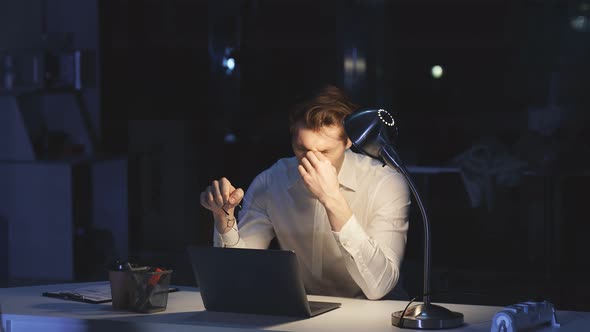 Closeup of a Man with Glasses Rubbing His Eyes From Fatigue and Night Work at the Computer