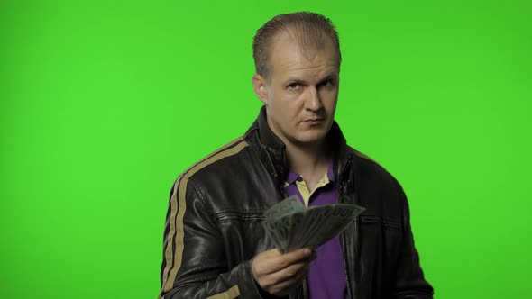 Rocker Man Employee Take Money Dollar Cash Banknotes Out of His Pocket and Offers Them To the Camera alt