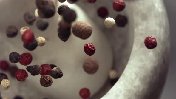Granite Mortar and Colored Pepper Grain Spice Species Falling in Slow Motion alt