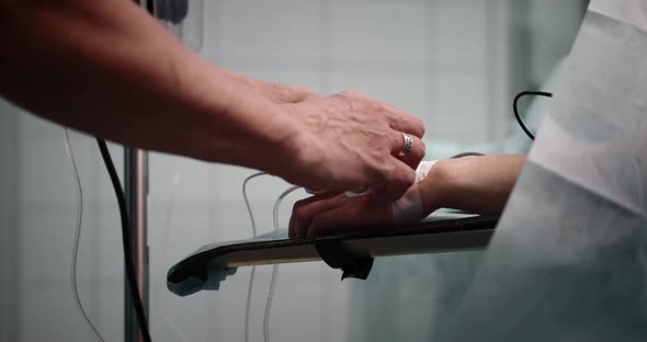 Preparing for surgery. A doctor with an assistant are installing an infusion system alt