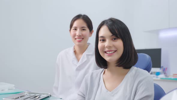 Portrait of professional dentist with young beautiful girl patient toothy smiling at dental clinic. alt