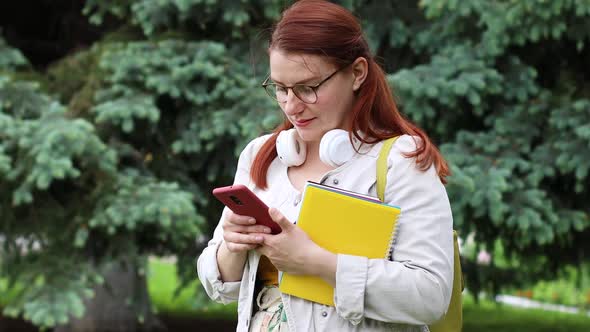 Learning Online Caucasian Girl Student Uses a Smartphone During a Break