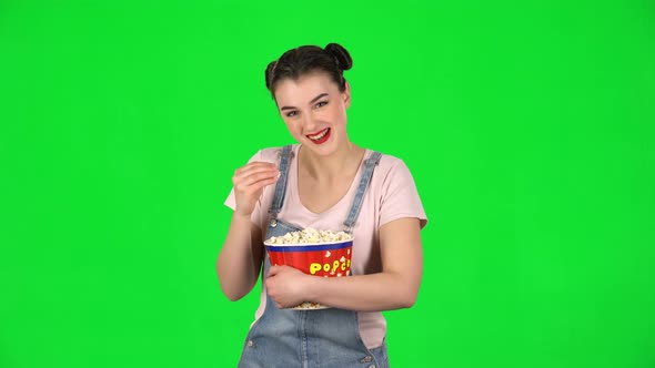 Sweet Girl Chews Popcorn While Watching a Movie and Laughing alt