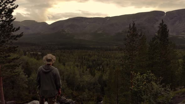 An Explorer Observing Mountain Valley with Woodland in the Khibiny at Dusk