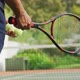 Video of hands of biracial senior man holding racket and starting match on tennis court