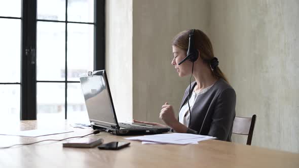 Young woman leads a remote meeting via laptop and shows graphs of growth alt