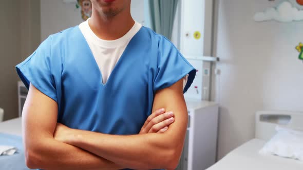 Doctor standing with arms crossed in hospital alt