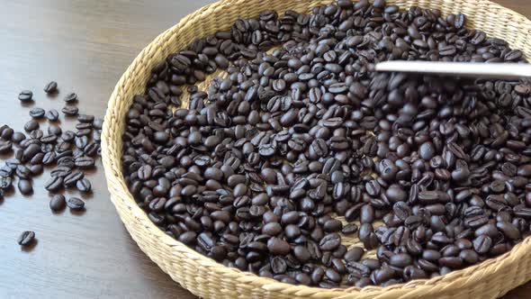 Roasted coffee beans closeup. Fragrant coffee beans. Scoop stir coffee beans.