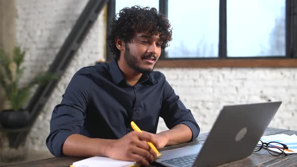 Intelligent Indian Businessman Involved Virtual Meeting on the Laptop Sitting in Modern Office alt