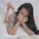 Asian girl reading a book falls in love with her favorite novel as she lies in bed. - VideoHive Item for Sale