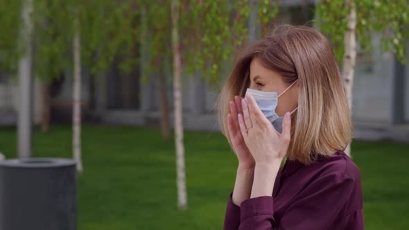 Business woman puts on face medical mask to protect sitting on bench park city alt