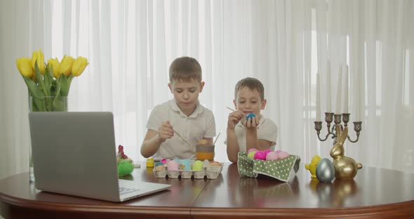 Two Boys Paint Easter Eggs and Greet Each Other alt