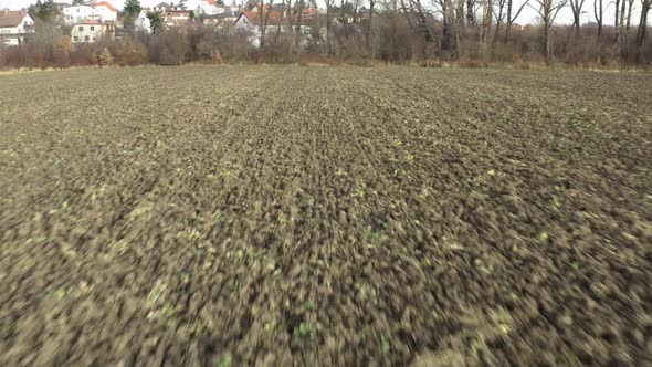 Aerial Shot of Plowed Empty Field During Winter on Day - Buildings in the Background - Fast Move alt