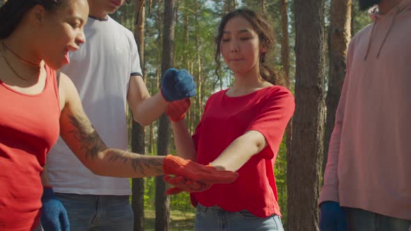 Diverse Eco Volunteers Making Pile of Hands Outdoors alt