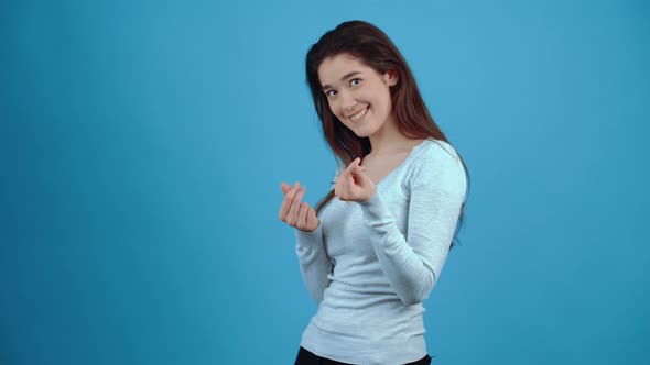 The Charismatic Young Brunette Looks Chic and Asks for Her Money Through Repeated Finger Rubbing alt