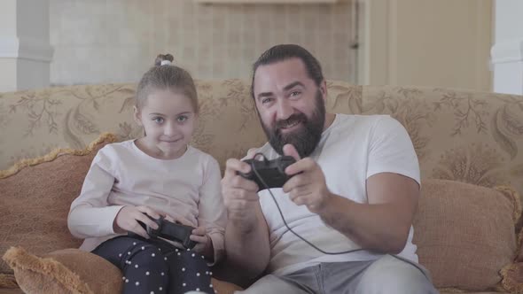 Portrait Cute Small Daughter with Her Funny Father Playing Video Games on Tv with Great Emotions in alt
