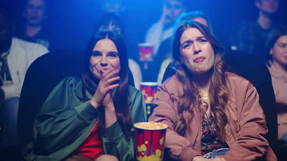 Smiling Girls Spending Time in Movie Theater. Women Looking Film in Cinema. alt