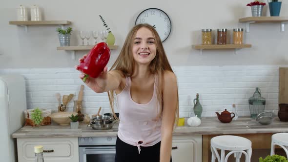 Girl Recommending Eating Raw Vegetable Food. Showing Pepper in Hands. Weight Loss and Diet Concept alt